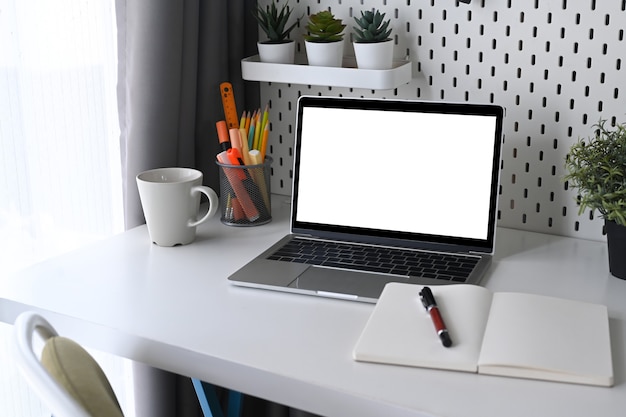 Mock-se, laptop, planta de casa e notebook na mesa do escritório em casa.