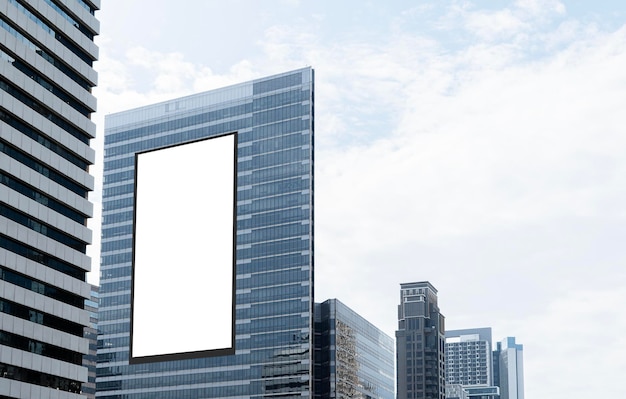 Mock up blanco vertical gran cartel de visualización LED en el edificio de la torre con fondo de cielo azul Camino de recorte para la maqueta