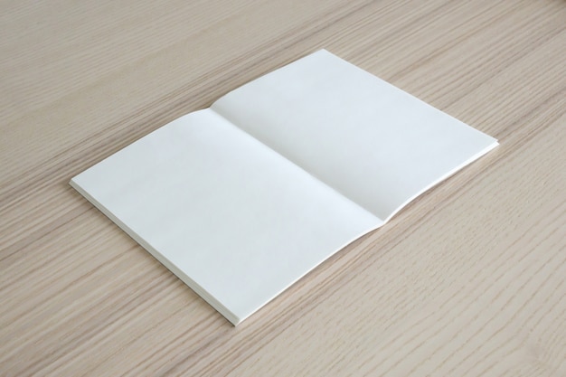 Mock up em branco livro de papel aberto na mesa de madeira