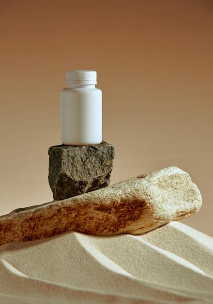 Mock up frasco de plástico no pódio de pedra no pacote de modelo de areia do deserto de suplementos dietéticos de vitaminas