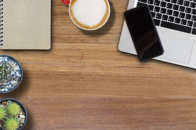 Mock up Handy auf Laptop und heißen Kaffee und Buchcover von Braun und Kaktus