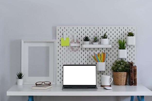 Mock-up-Laptop-Computer mit leerem Bildschirm auf weißem Schreibtisch im Büro