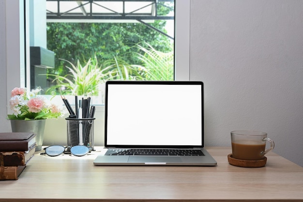 Mock-up-Laptop-Computer mit weißem Bildschirm auf Holztisch im Wohnzimmer