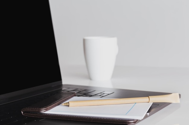 Mock up laptop de tela em branco e xícara de café com outros materiais de escritório