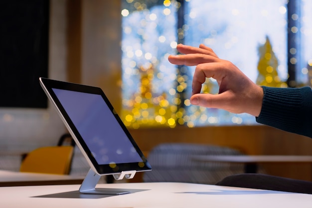 Mock-up-Technologie. Geschäftsmann zeigt OK auf dem Hintergrund eines digitalen Tablets mit weißem Bildschirm.