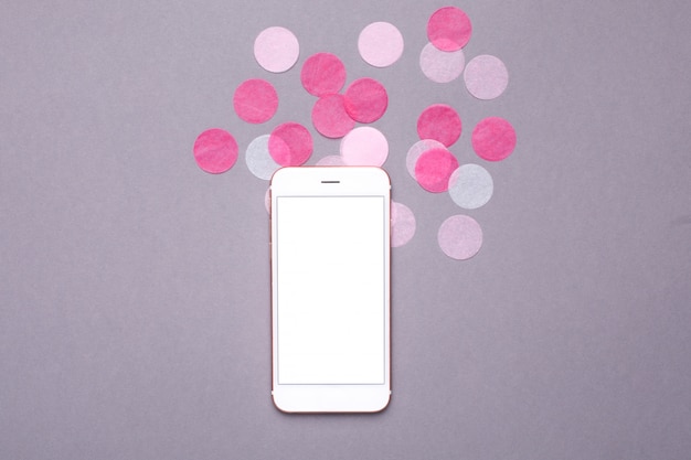 Mock up de teléfono móvil con confeti rosa sobre gris