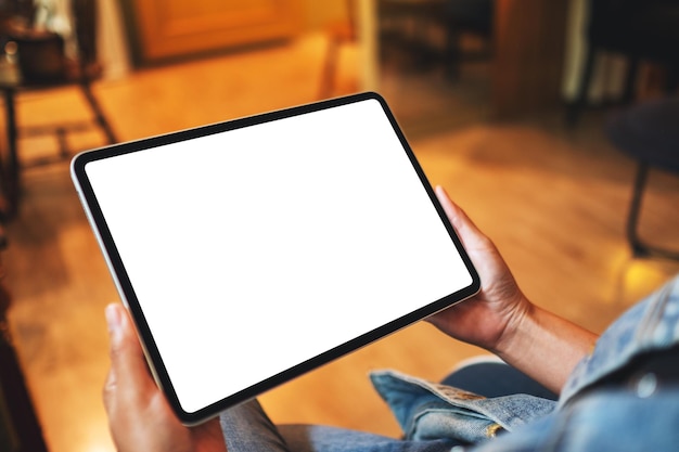 Mockup-Bild einer Frau, die ein digitales Tablet mit einem leeren weißen Desktop-Bildschirm hält