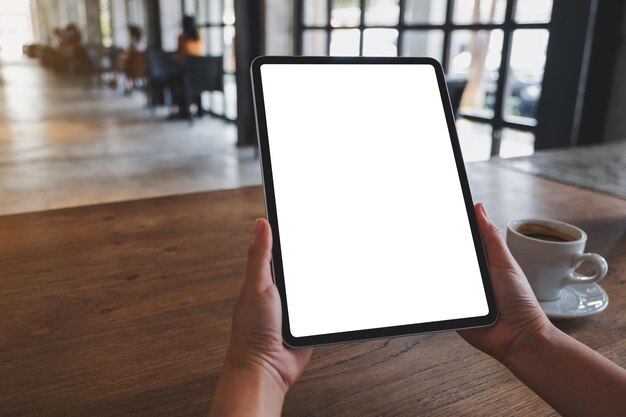 Mockup-Bild einer Frau, die ein digitales Tablet mit einem leeren weißen Desktop-Bildschirm hält