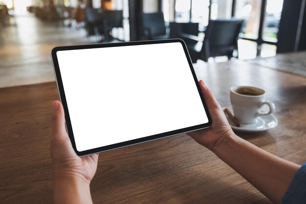Mockup-Bild einer Frau, die ein digitales Tablet mit einem leeren weißen Desktop-Bildschirm hält