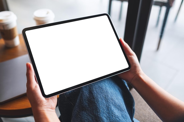 Mockup-Bild einer Frau, die ein digitales Tablet mit einem leeren weißen Desktop-Bildschirm hält