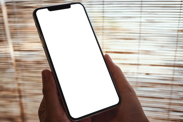 Mockup-Bild einer Frau, die ein Handy mit einem leeren weißen Desktop-Bildschirm hält