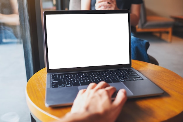 Mockup-Bild eines Mannes, der ein Laptop-Touchpad mit einem leeren weißen Desktop-Bildschirm verwendet und berührt