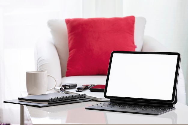 Mockup-Bildschirm mit leerem Bildschirm und Tastatur auf weißem Tisch im Wohnzimmer zu Hause.