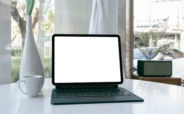 Mockup-Bildschirm mit leerem Bildschirm und Tastatur auf weißem Tisch.