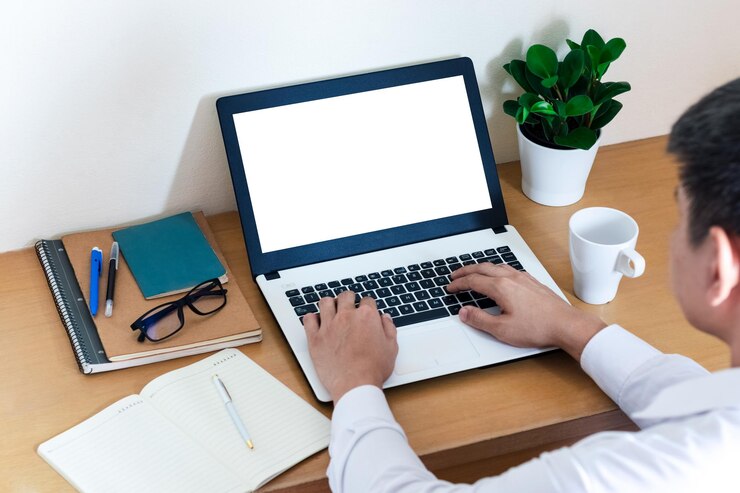 Foto mockup copy space computer notebook laptop conceito de uma mão de homem usando um laptop em sites da internet no escritório teclados em computador portátil com balnk tela de cópia para o seu conteúdo publicitário