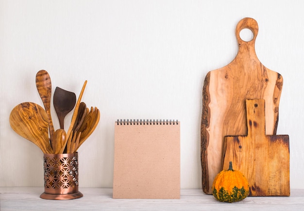 Foto mockup de ação de graças com caderno de abóbora, tábuas de madeira e utensílios de cozinha de madeira