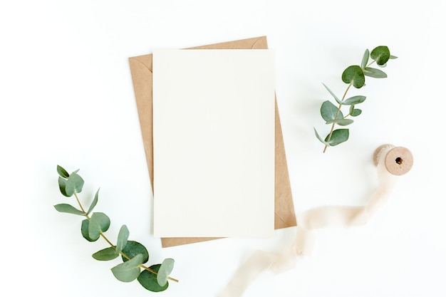 Mockup de convite cartão de saudação em branco e folhas verdes eucalipto plano lay vista superior
