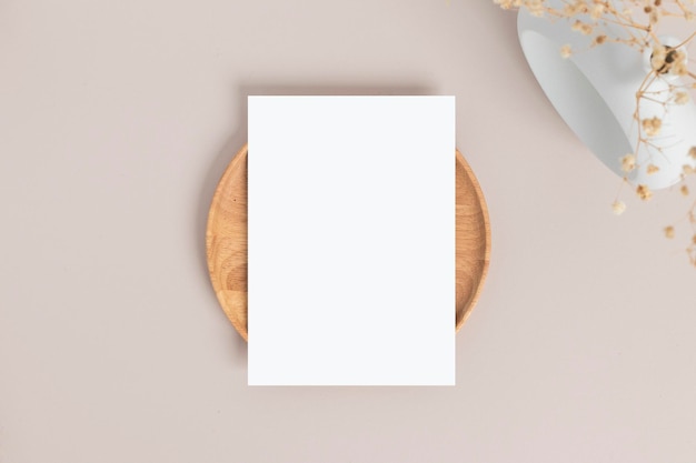 Mockup de convite de cartão em branco 5x7 no envelope com flores secas e fita na maquete plana de fundo de papel