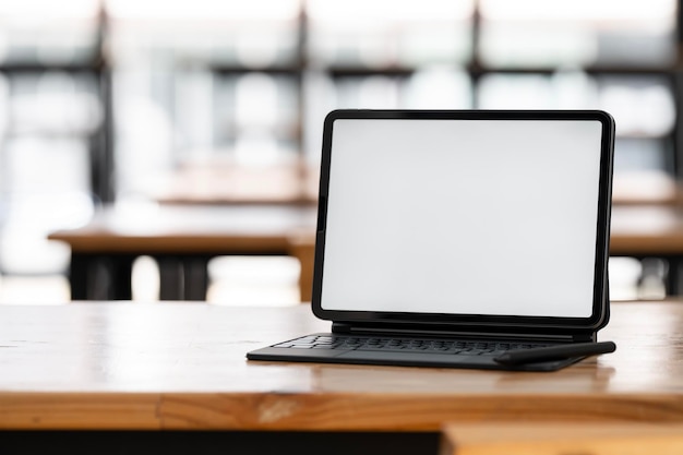 Mockup de tela em branco tablet digital com teclado mágico em mesa de madeira