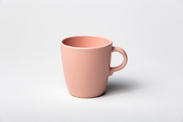 Mockup einer Teetasse oder Kaffeetasse in rosa Farbe, isoliert auf einem einfachen Hintergrund, bereit, Designs oder Logos für Merchandising zu überlagern