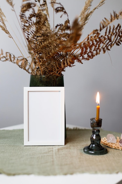 Mockup in der Nähe einer Vase und einer Kerze