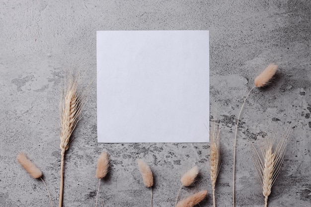 Mockup de invitación de volante cuadrado blanco sobre fondo gris