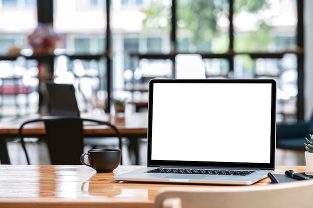 Mockup-Laptop-Computer mit leerem Bildschirm auf Holztisch im Café-Raum, leerer Bildschirm für Grafikdesign.