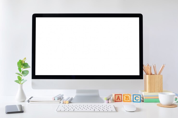 Foto mockup monitor de computadora de escritorio y suministros de oficina.