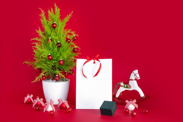 Mockup de navidad sobre fondo rojo con regalo de año nuevo y elementos decorativos