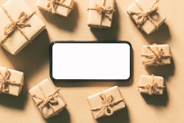 Mockup smartphone con caja de regalo de año nuevo de pantalla blanca en blanco con modelo de árbol de pino de Navidad