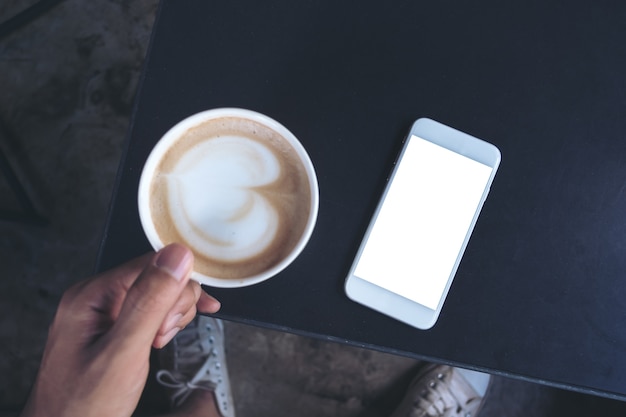 Mockup-Telefon mit Kaffeetasse