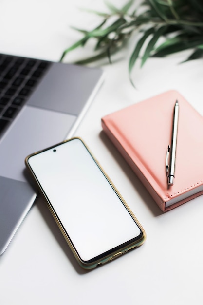 Mockup de teléfono móvil. Lugar de trabajo femenino con ordenador portátil y teléfono.