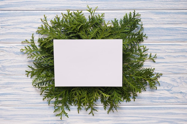 Mockup Weihnachtsgrußkarte und Tannenzweige auf blauem Holzhintergrund