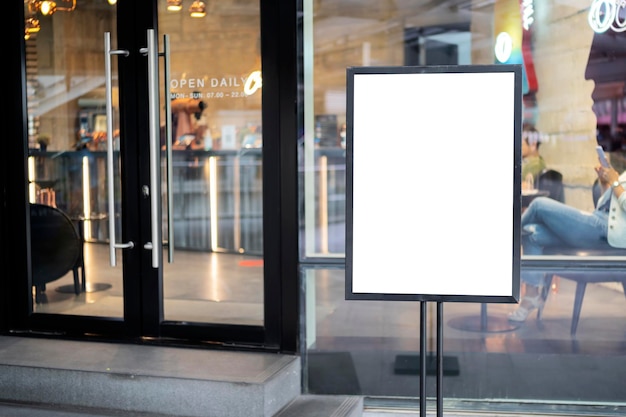 Foto mockup weißes poster mit schwarzem rahmen vor verschwommenem restaurant-café-hintergrund