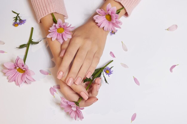 Moda arte cuidado de la piel de manos y flores rosas en manos de mujeres