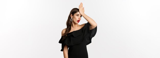 Foto la moda y la belleza molestaron a la mujer elegante con vestido negro que se abofetea la frente haciendo facepalm y pone los ojos en blanco