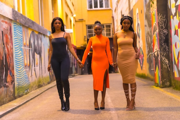 Moda de estilo urbano com três meninas negras africanas em uma rua da cidade