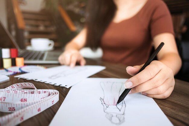 Foto moda / diseñador creativo de trabajo con cuaderno de dibujo en el estudio casero moderno, enfoque selectivo