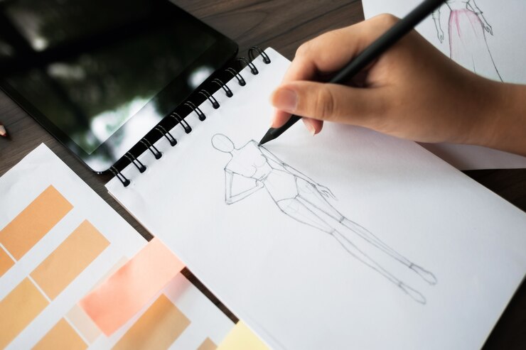 moda / diseñador creativo de trabajo con cuaderno de dibujo en el estudio casero moderno, enfoque selectivo