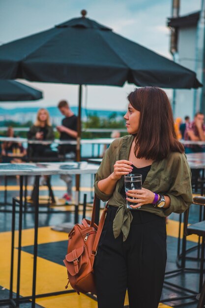 Moda elegante mulher segurando copo de bebida no café confortável e aconchegante