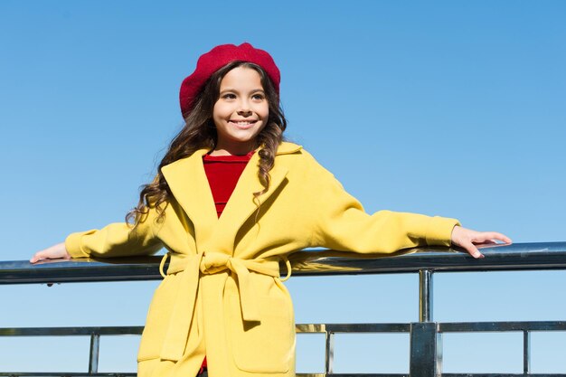 Moda francesa. verdadeiro parisiense. moda infantil. menina elegante depois de cabeleireiro. ela tem cabelo encaracolado irreal. aproveite o dia de outono. sorte com o clima. alegre mocinha. menina ao ar livre.