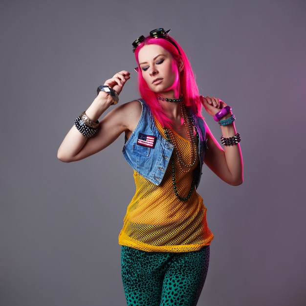 Moda futurista: uma jovem mulher atraente e brilhante com cabelo rosa