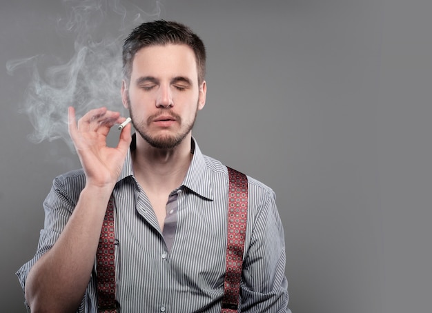 Foto moda homem fumando um cigarro