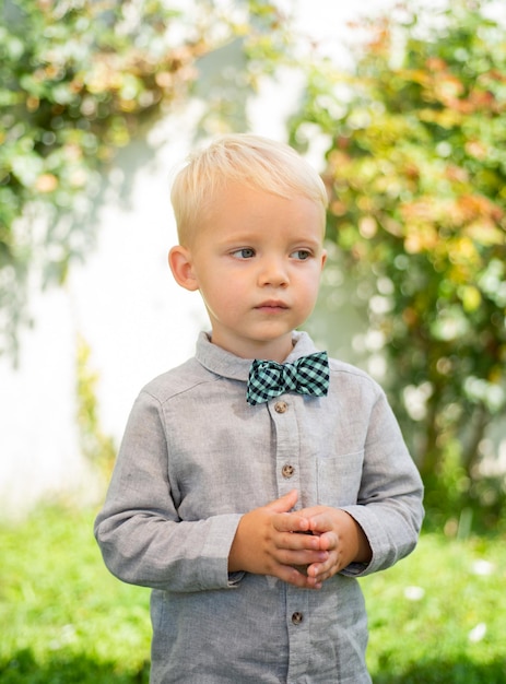 Moda infantil. Menino cavalheiro com gravata borboleta. Infância, juventude feliz.