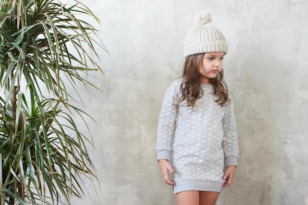 Moda infantil. Niña con estilo en vestido gris