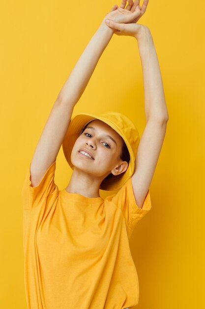 Moda jovem e bonita em camiseta amarela posando moda no fundo amarelo do panamá