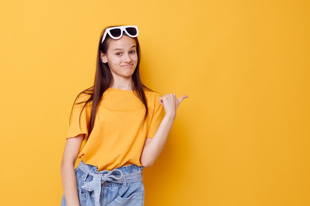 Moda jovem e bonita em camiseta amarela shorts jeans fundo amarelo