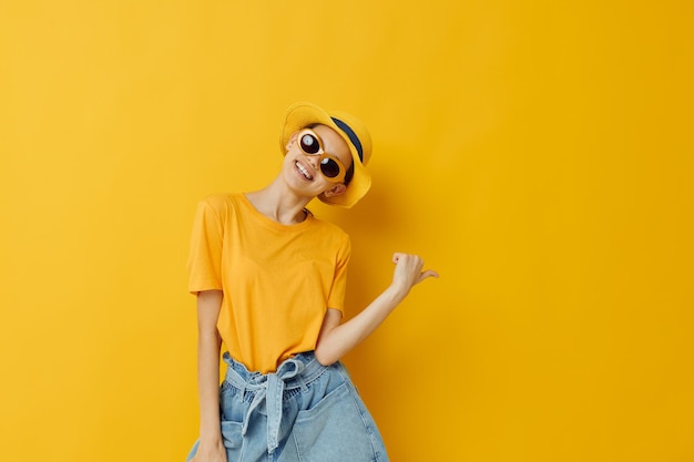 Moda jovem em camiseta amarela posando moda em fundo amarelo panamá