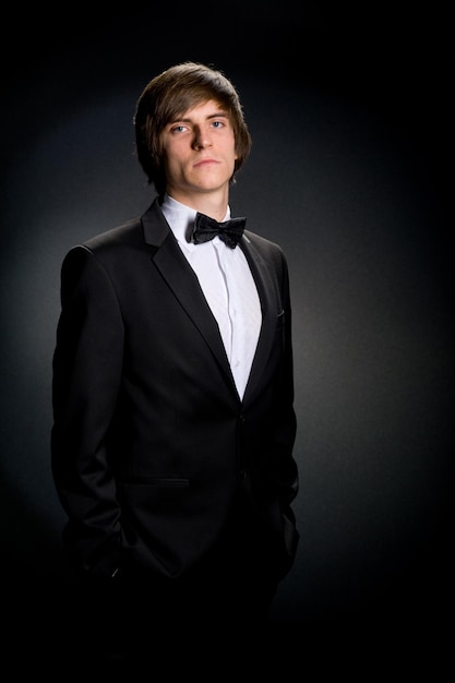 Moda jovem empresário terno preto gravata casual em fundo cinza