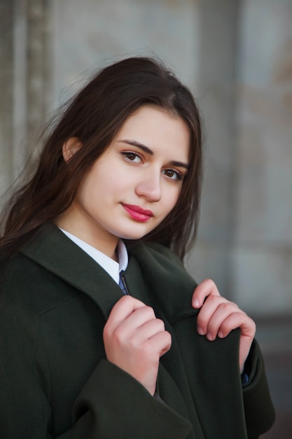 Moda joven hermosa mujer elegante en abrigo negro caminando en la calle. Tendencia de la moda de otoño para mujeres sonrientes, felices y decididas